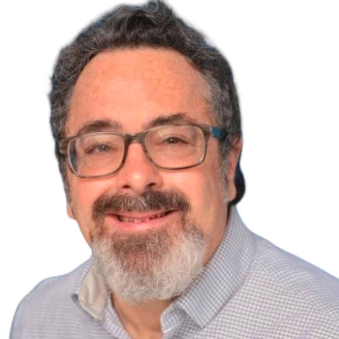 Man with glasses, beard, and gray shirt smiling confidently outdoors